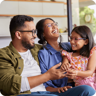 Family sitting on a couch laughing.
