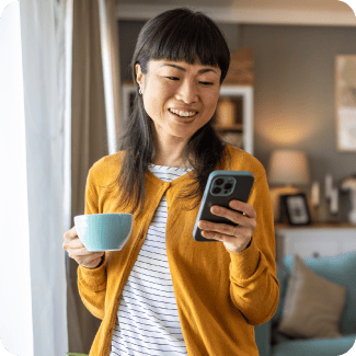 Woman looking at her phone and drinking coffee.