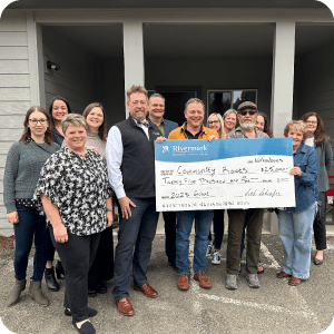 Rivermark team donating money with a large check.