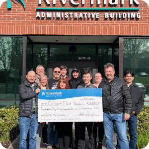Team Rivermark holding a giant check donation.