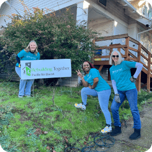 A group of people from Rivermark and Rebuilding Together outside a home.