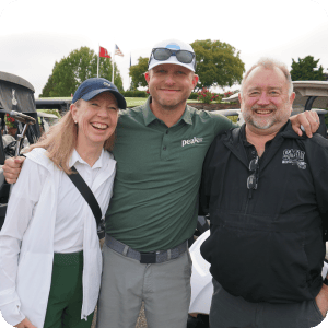Three golfers smiling and enjoying the sunny day.