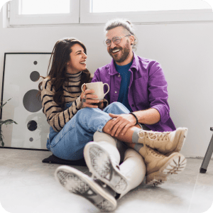 Couple sitting on the floor of their new home.