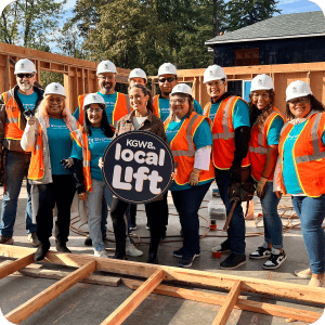 A group of people from Local Lift in construction gear holding a sign reading KGW8 Local Lift.