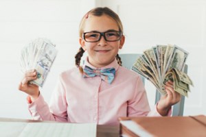 Young girl with glasses holding money