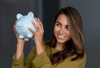 Woman holding a blue piggy bank.